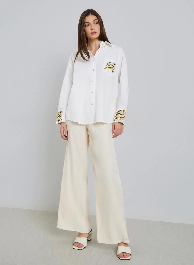 ستايلي بلوزة واسعة بتفاصيل مُطرّزة مع أكمام بأساور